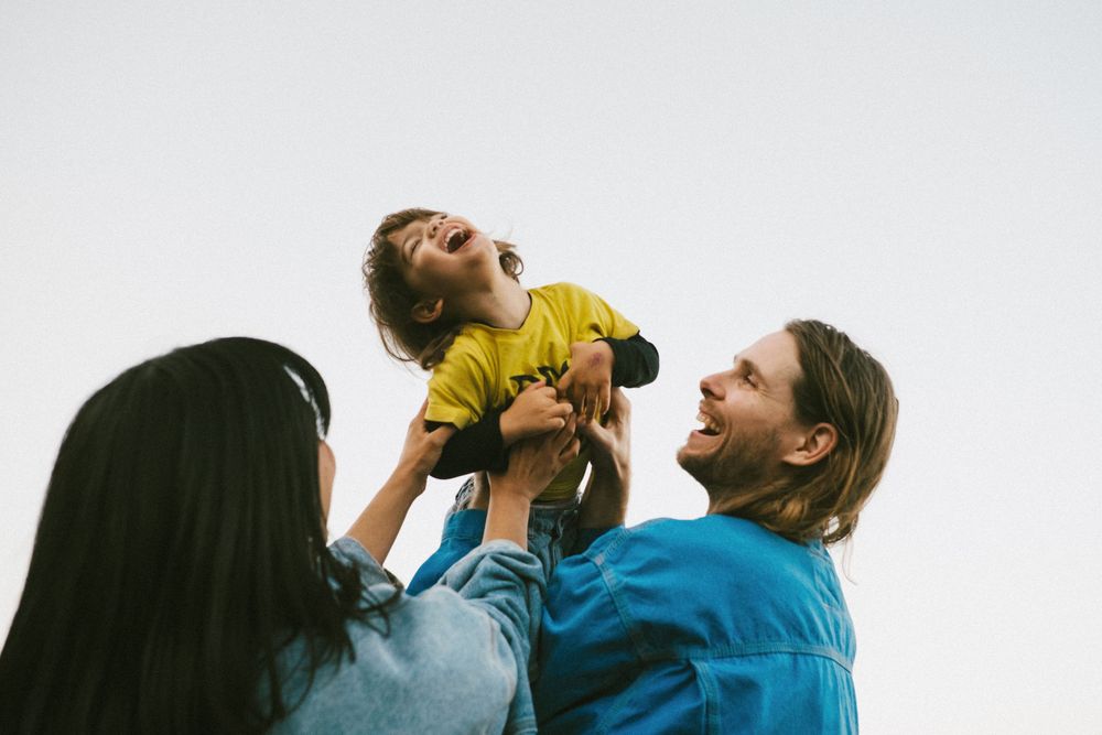 Joyful family interaction outdoors against white background.