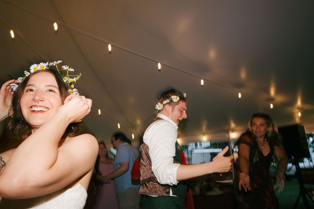 Wedding celebration with people dancing under string lights at night.