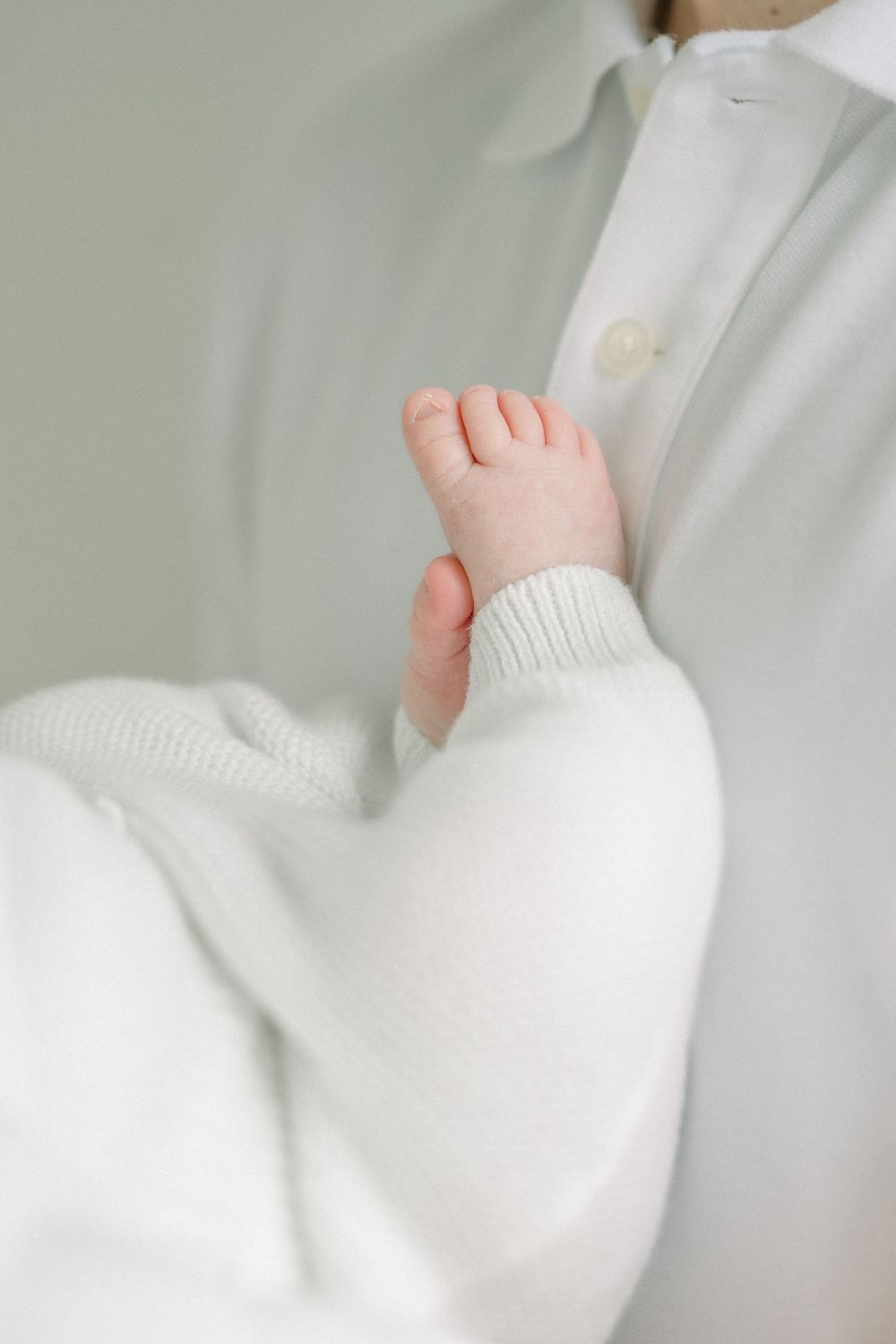 Delicate white knit fabric close-up showcasing soft texture and gentle folds in natural light.