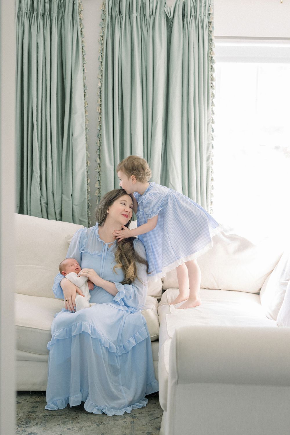 A sequence of photos showing a person in a light blue ruffled dress lounging gracefully on a white couch near mint curtains.