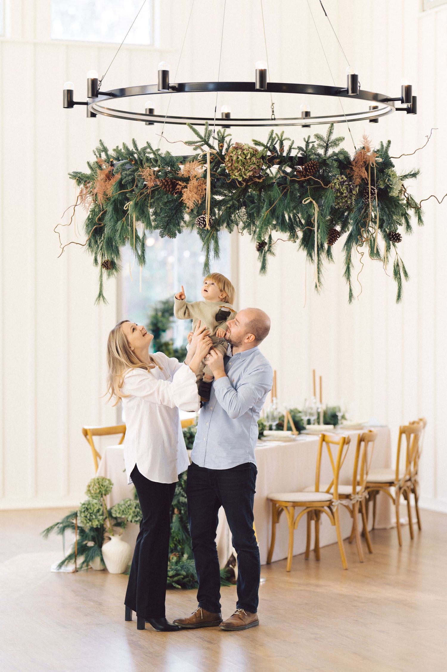 A dance couple in black and white outfits practice their steps in an elegant white room with holiday garland decorations.