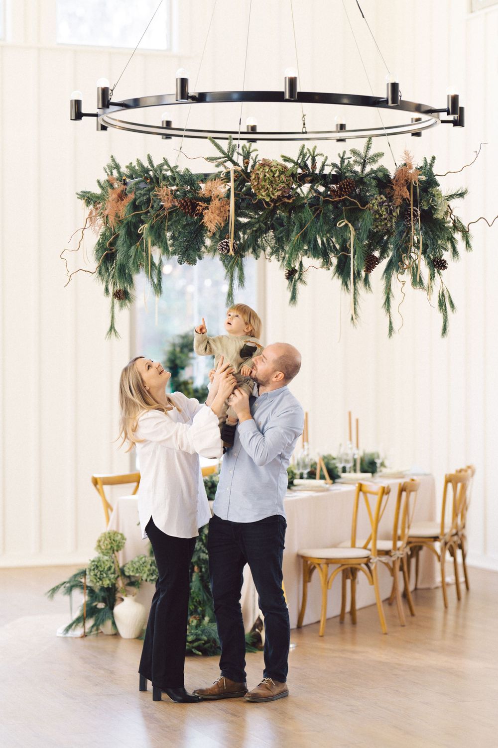 A dance couple in black and white outfits practice their steps in an elegant white room with holiday garland decorations.