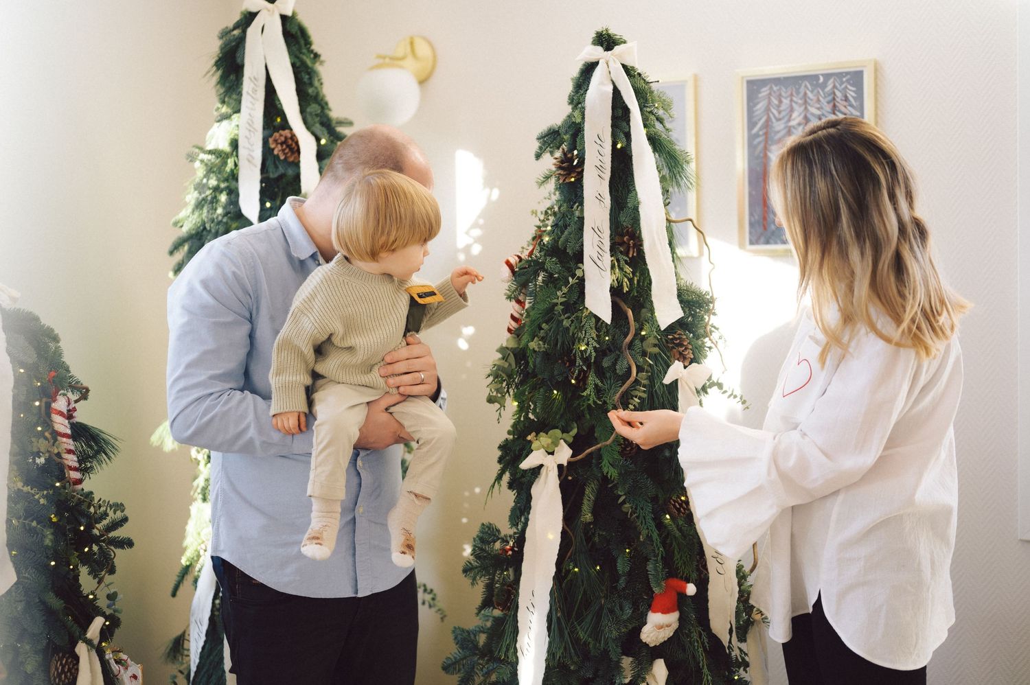 A series of images showing people gathering around and decorating a Christmas tree with white lights and ornaments.