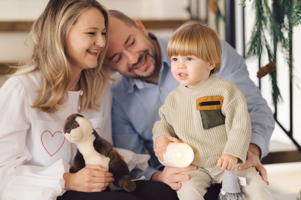 A loving family shares joyful moments together in a cozy living room setting with warm lighting and natural decor.