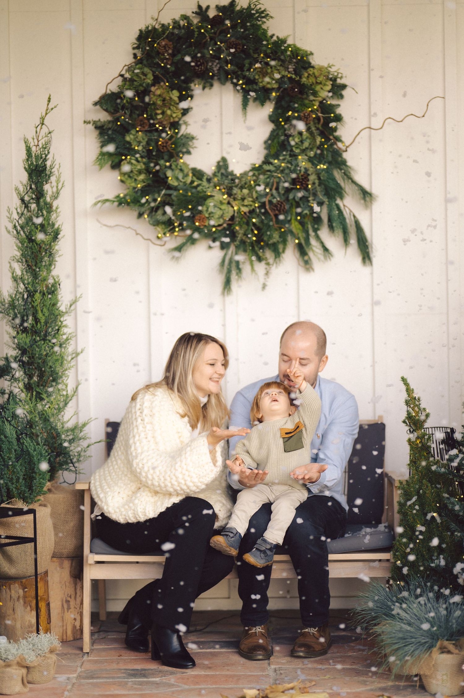 A romantic holiday photo sequence shows a couple seated on a wooden bench with evergreen and Christmas decorations in the background.