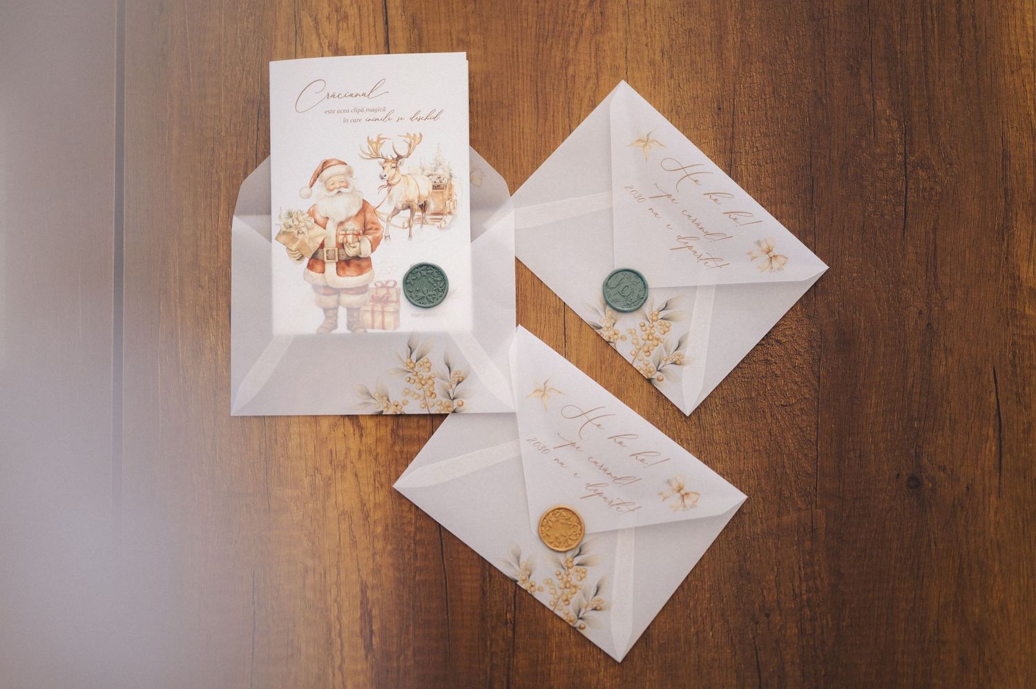 Wedding invitation envelopes with floral designs and wax seals lay on a wooden surface.