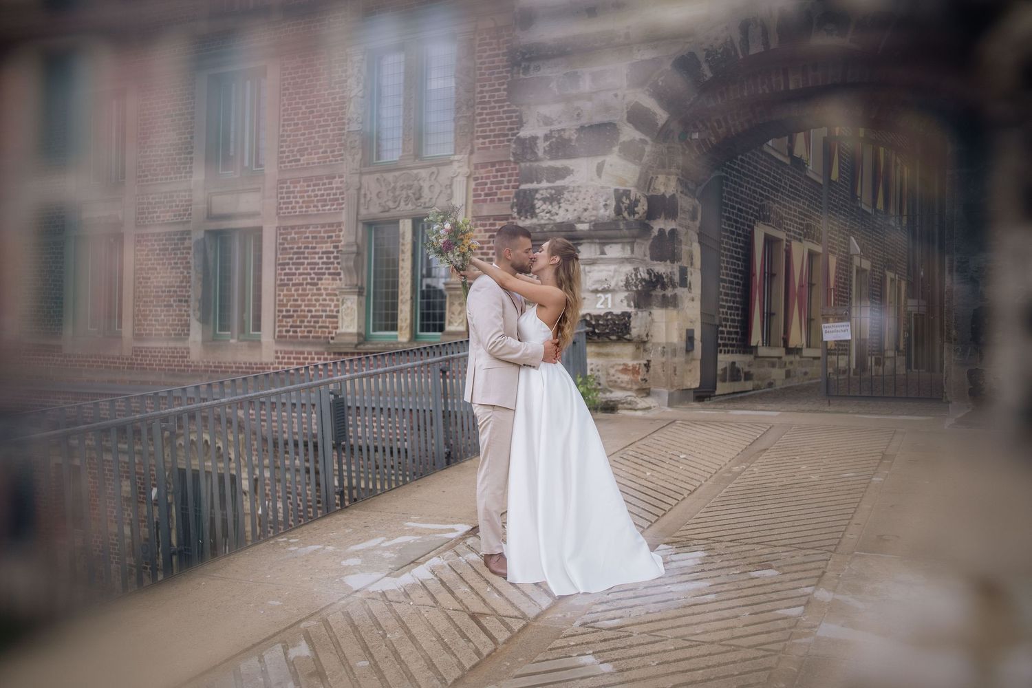 Stone building facade creates dramatic backdrop for wedding photography sequence.