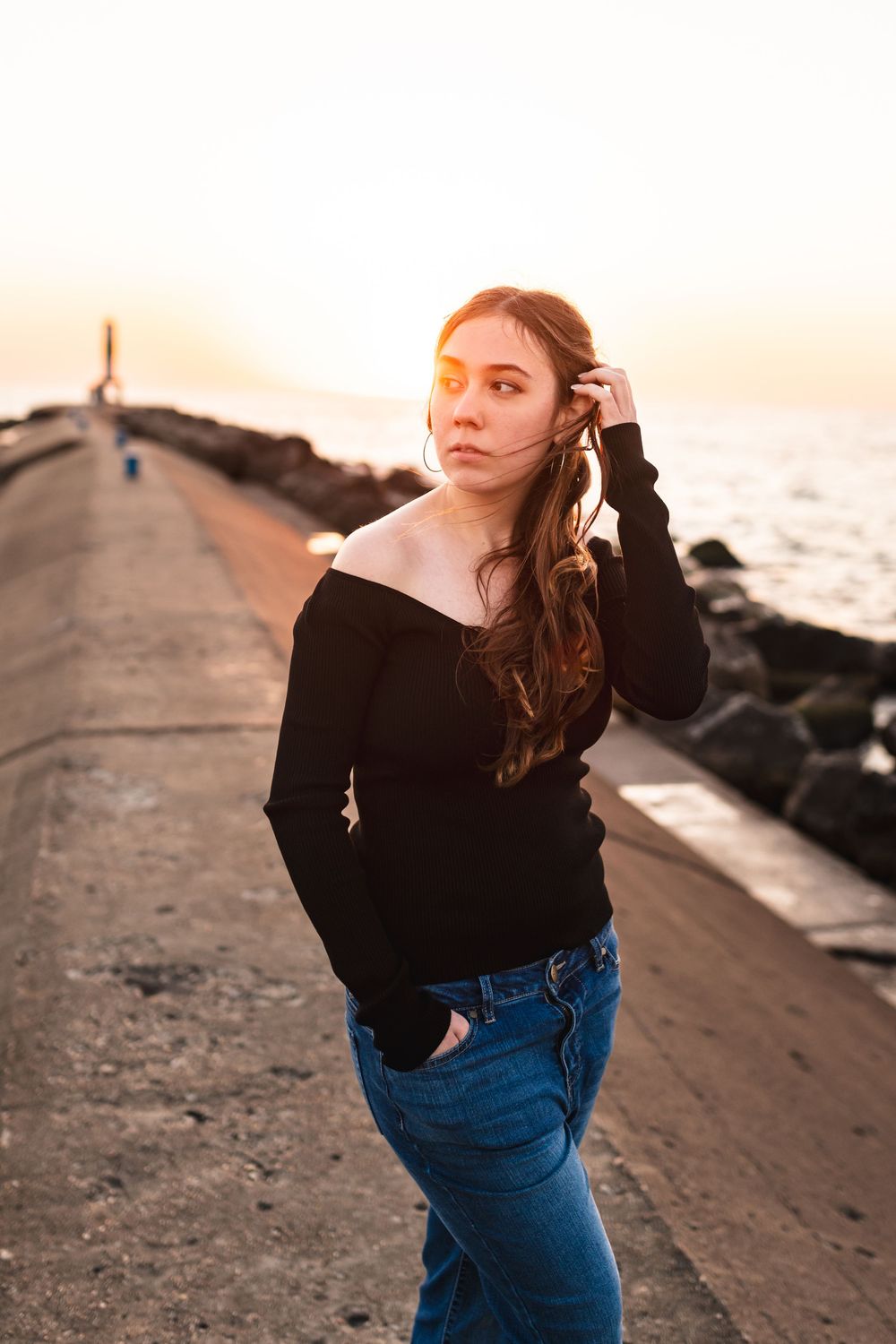 Senior girl standing on the Pier in Holland at golden hour.