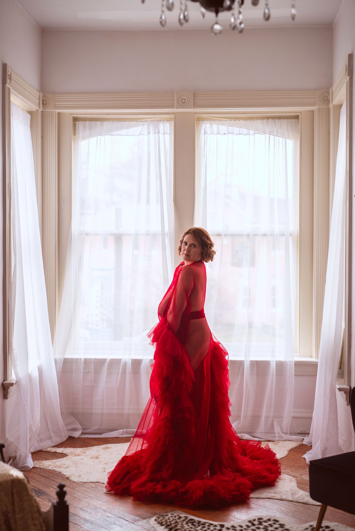 Woman with red hair wearing a red robe posing during her cape girardeau missouri boudoir session