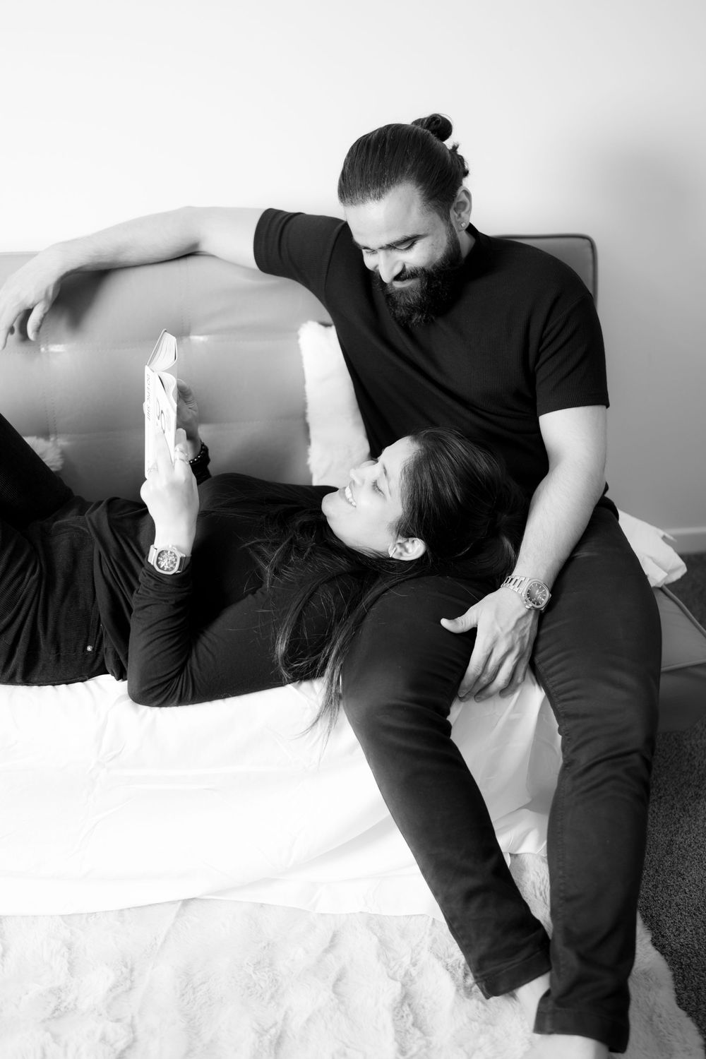 Black and white minimalist photo series showing a figure in dark clothing resting on a white surface.