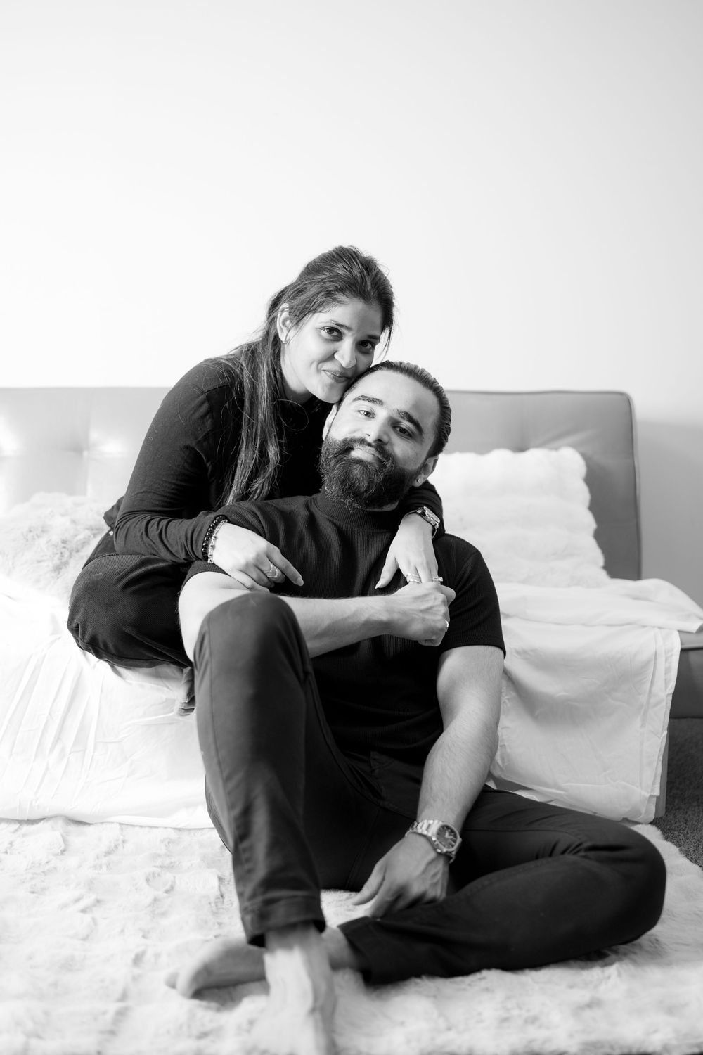 Series of black and white photos showing tender moments between two people sitting and laying on a couch.