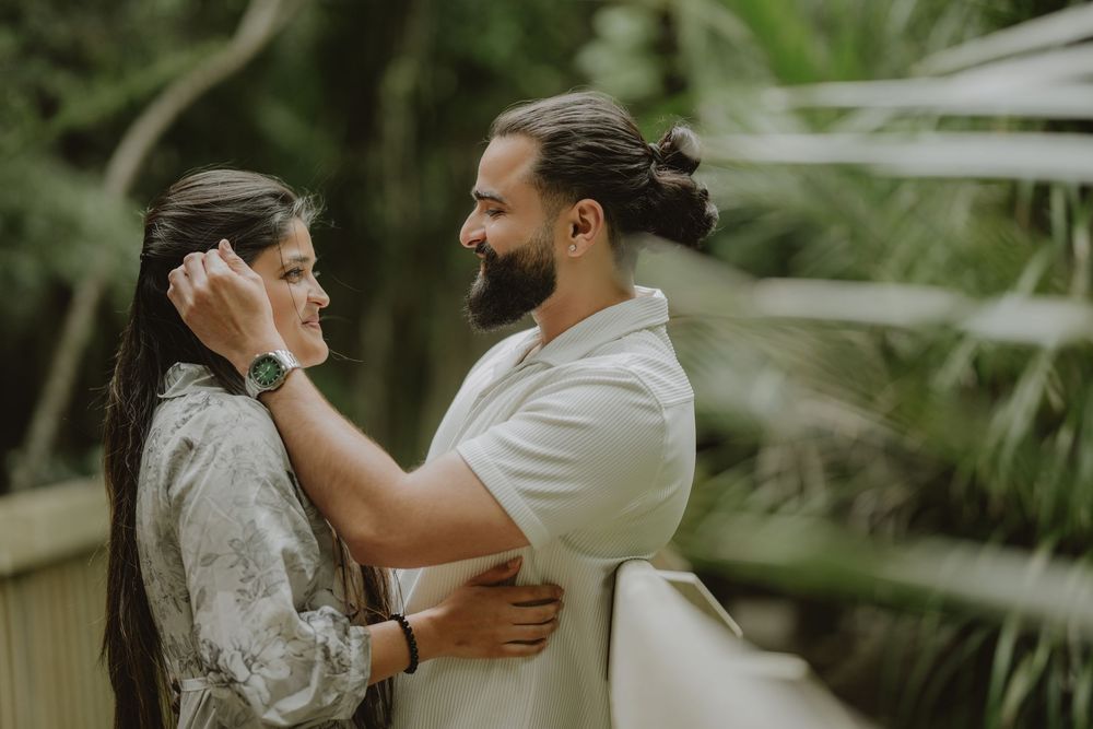 A romantic wedding couple embraces in a lush garden setting creating an intimate moment at their outdoor celebration.