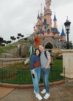 Tourists posing for photos in front of the iconic Disneyland Paris castle.