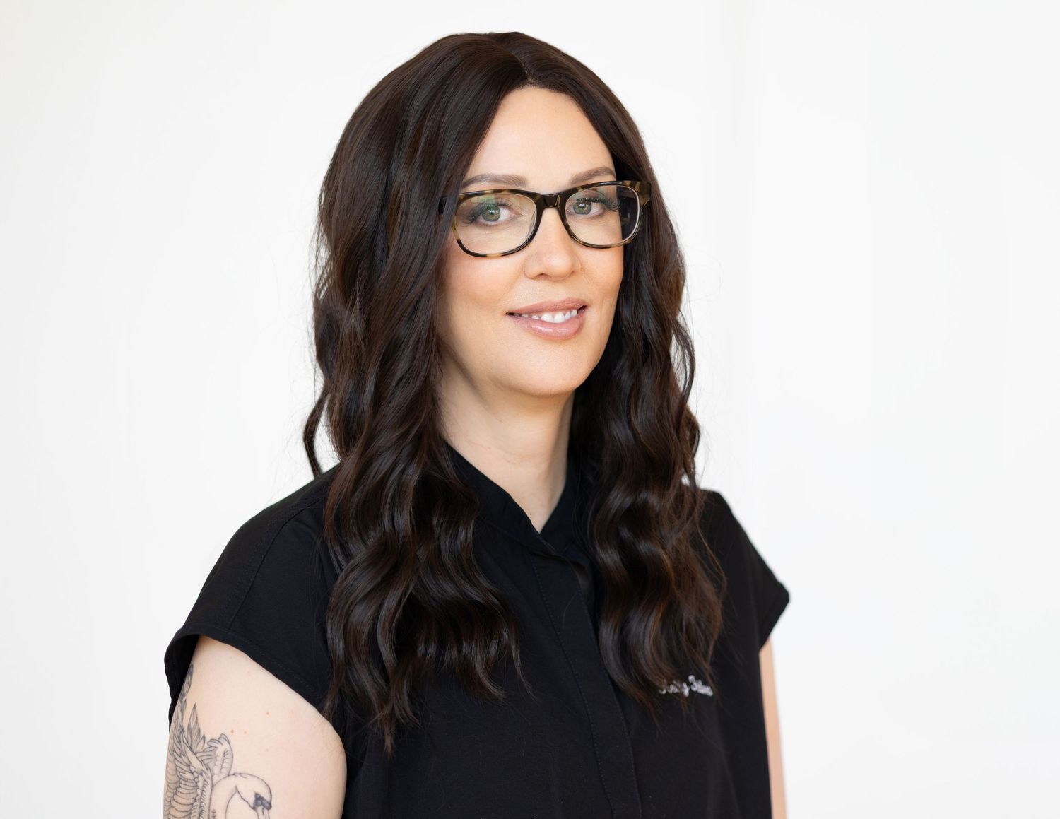 Corporate headshot of nurse injector Kelly Toldnes in London Ontario studio with neutral white backdrop, nurse scubs attire