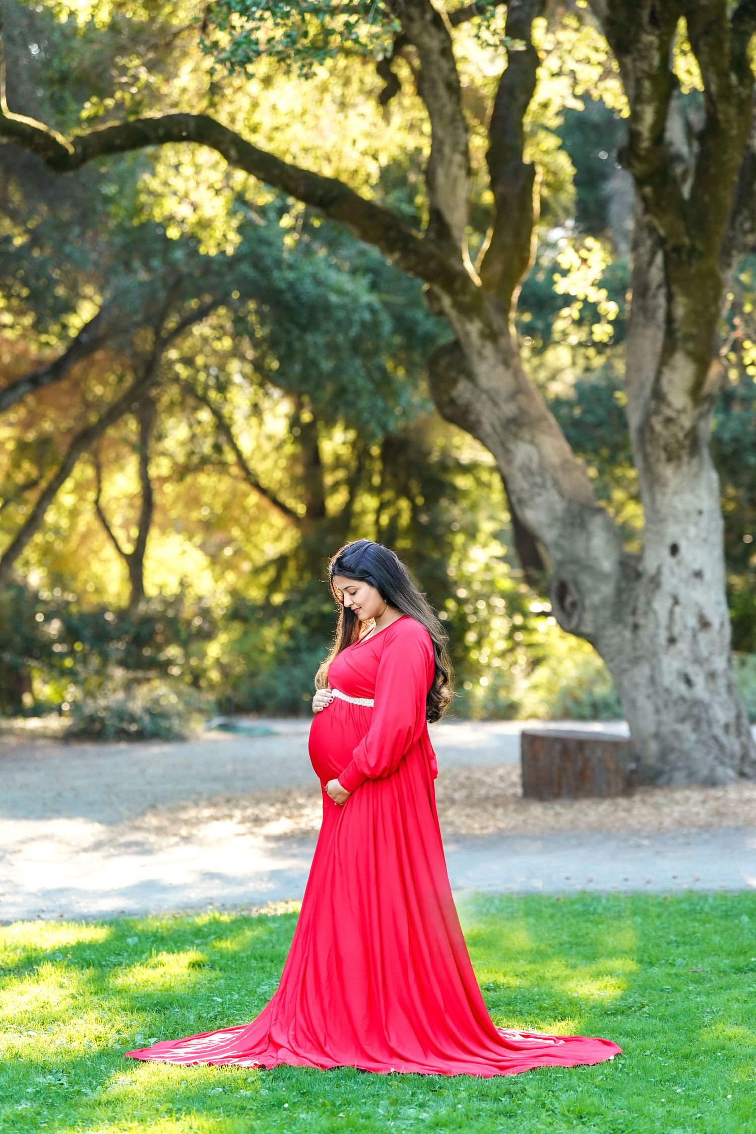 Bay Area maternity photography outdoors under natural light with flowing red gown.