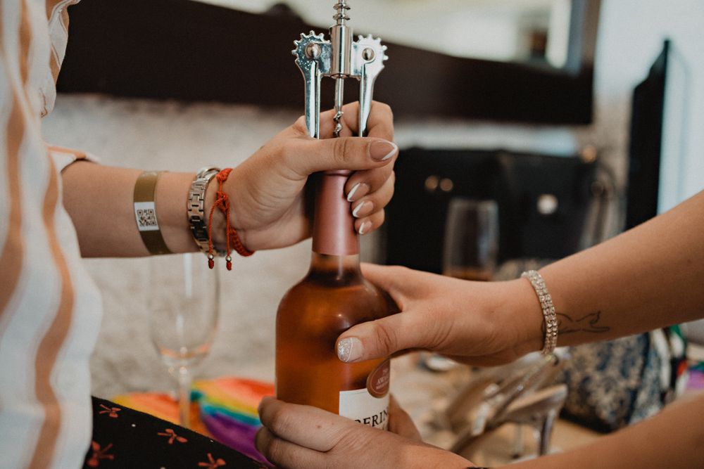 Novia abriendo una botella de vino durante el getting ready