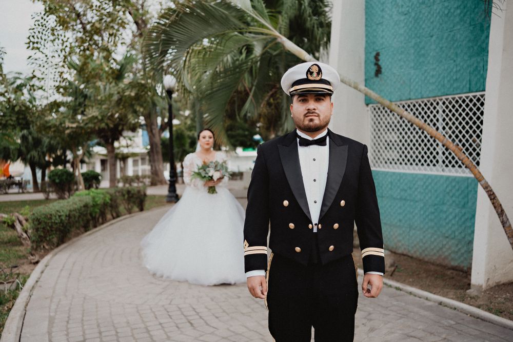 Novio esperando a la novia en el first look, ella detrás