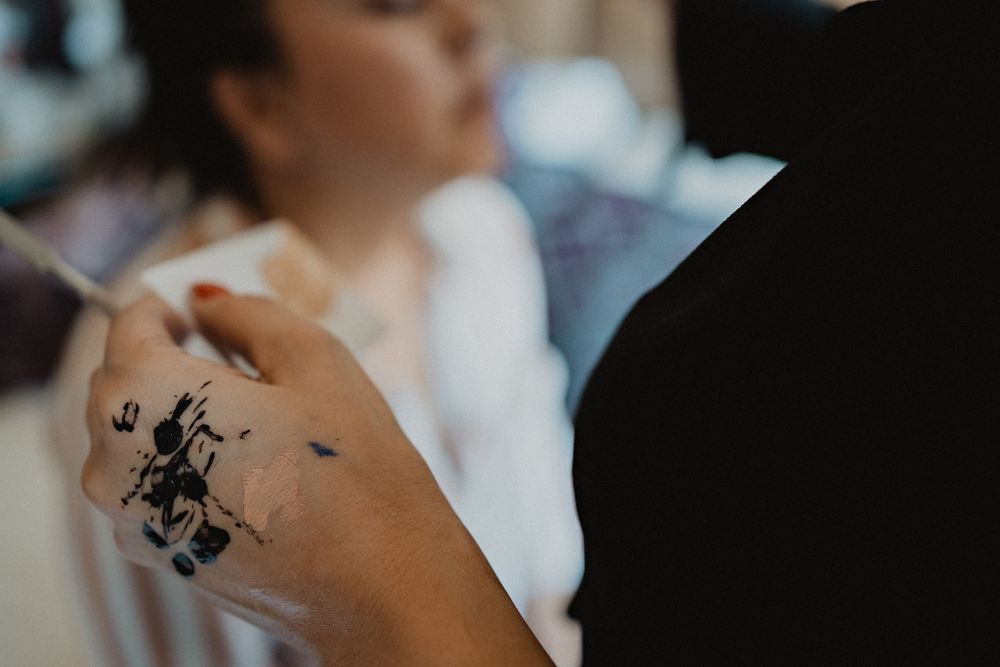 Mano de maquillista con tinta, detalle artístico en la preparación
