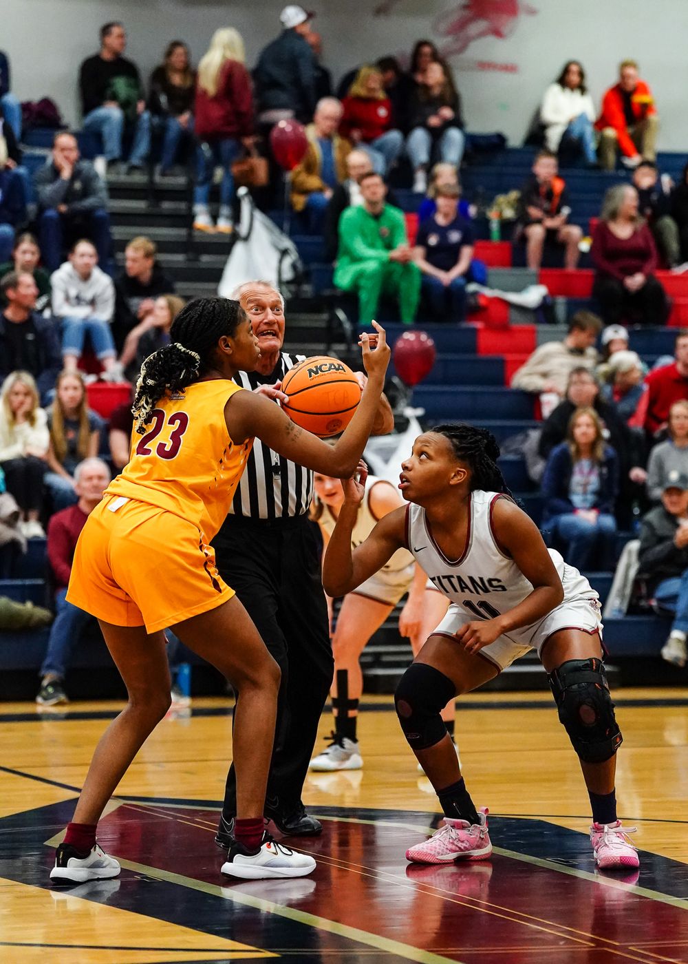 Two basketball players battle for position during competitive game action.
