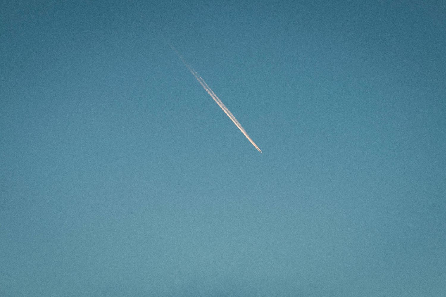 Flygplan mot en klarblå himmel i skymmning