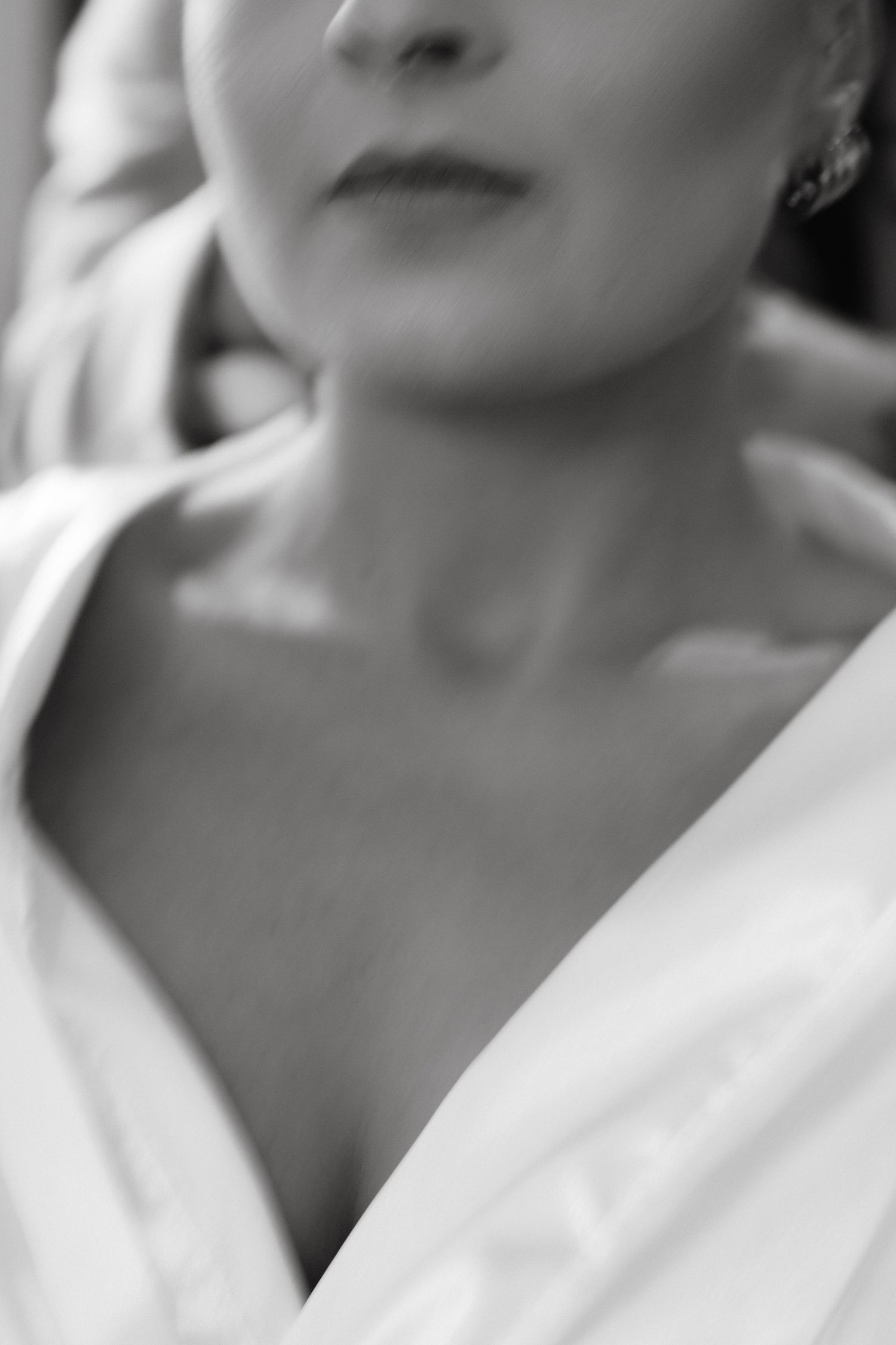 Close-up black and white portrait showing elegant bridal makeup and jewelry.