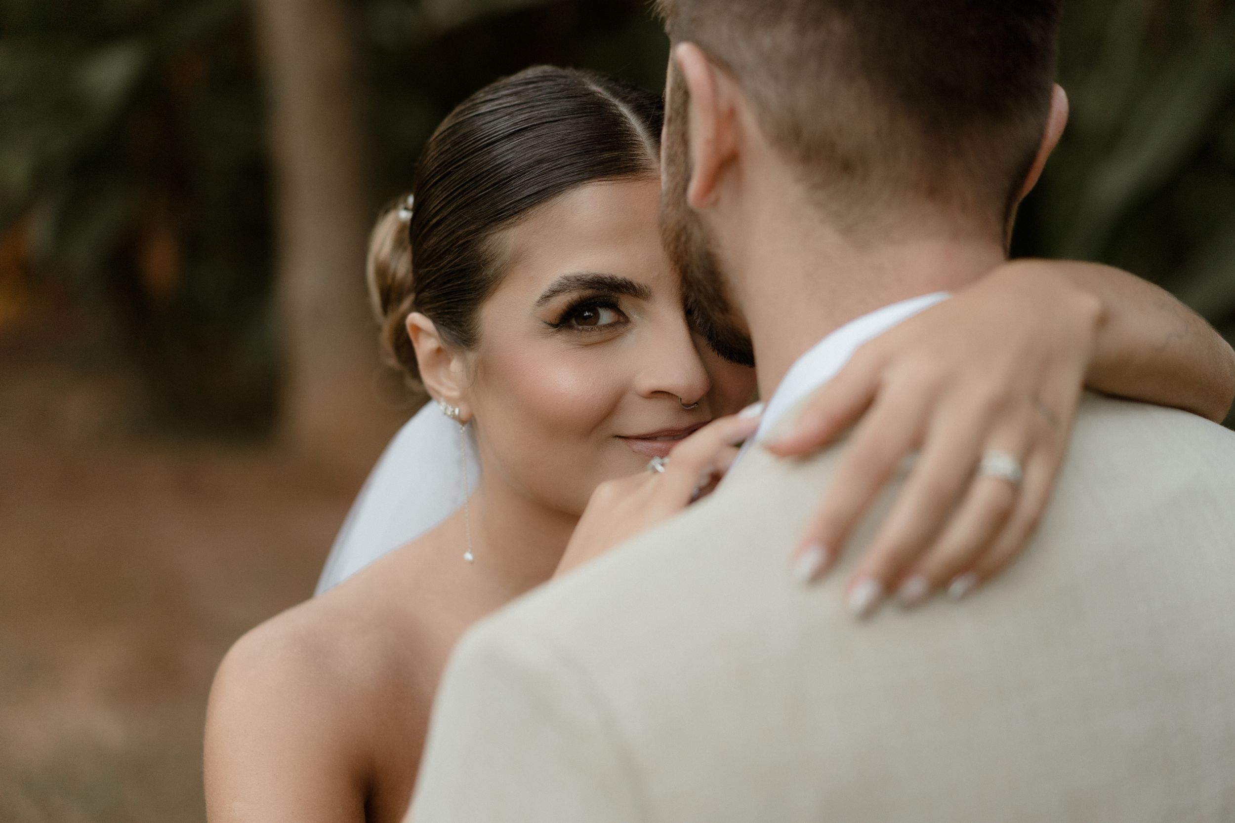 A tender moment between newlyweds against a natural backdrop.