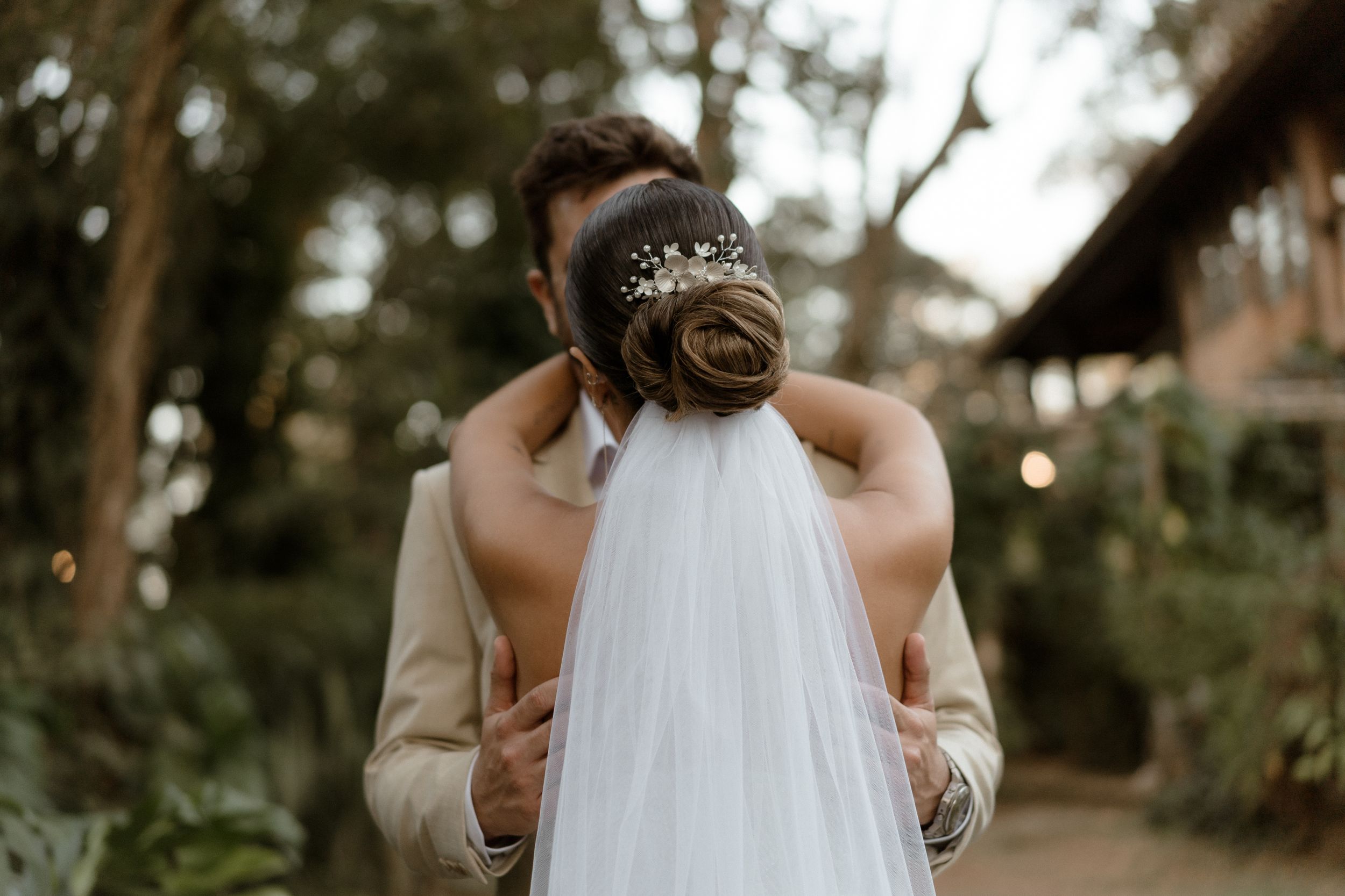 A close-up wedding portrait showing an ornate bridal headpiece and veil.