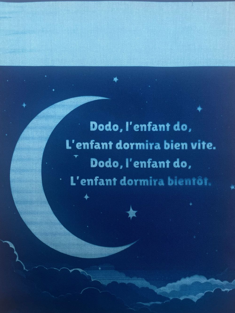 French text about sleeping children displayed with crescent moon illustrations in a dark blue nighttime scene.