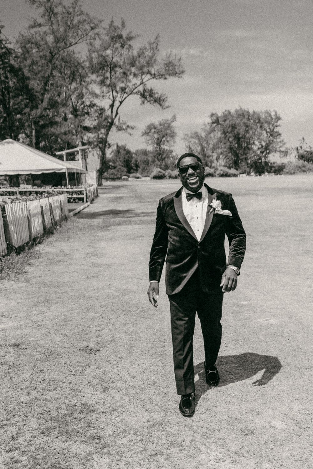 A sequence of black and white photos showing a person in a suit walking across an open field.