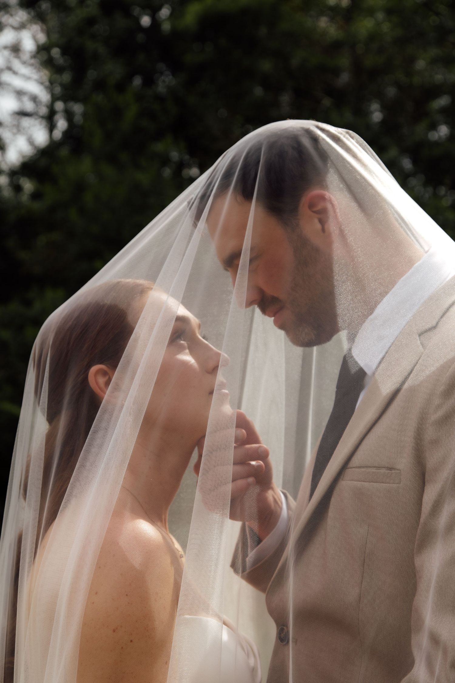 A romantic sequence of wedding photos showing a couple in profile under a delicate white veil sharing an intimate moment.