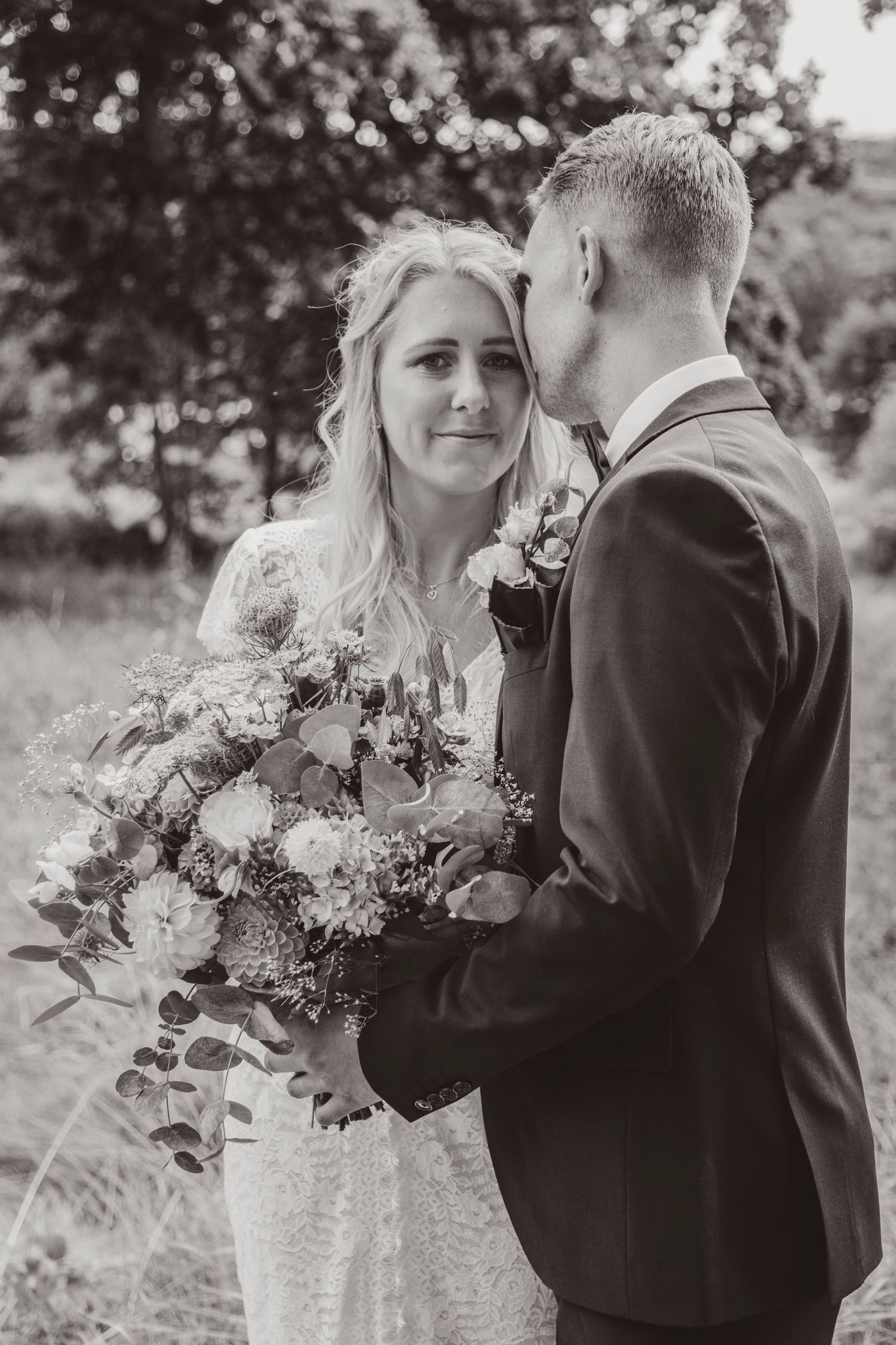 A romantic black and white wedding photo series showing intimate moments between newlyweds with a floral bouquet.