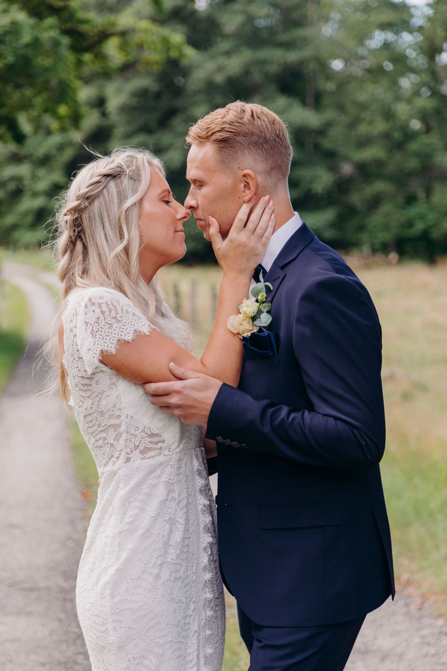 A romantic wedding sequence showing a couple in a white lace dress and navy suit embracing on a nature path.
