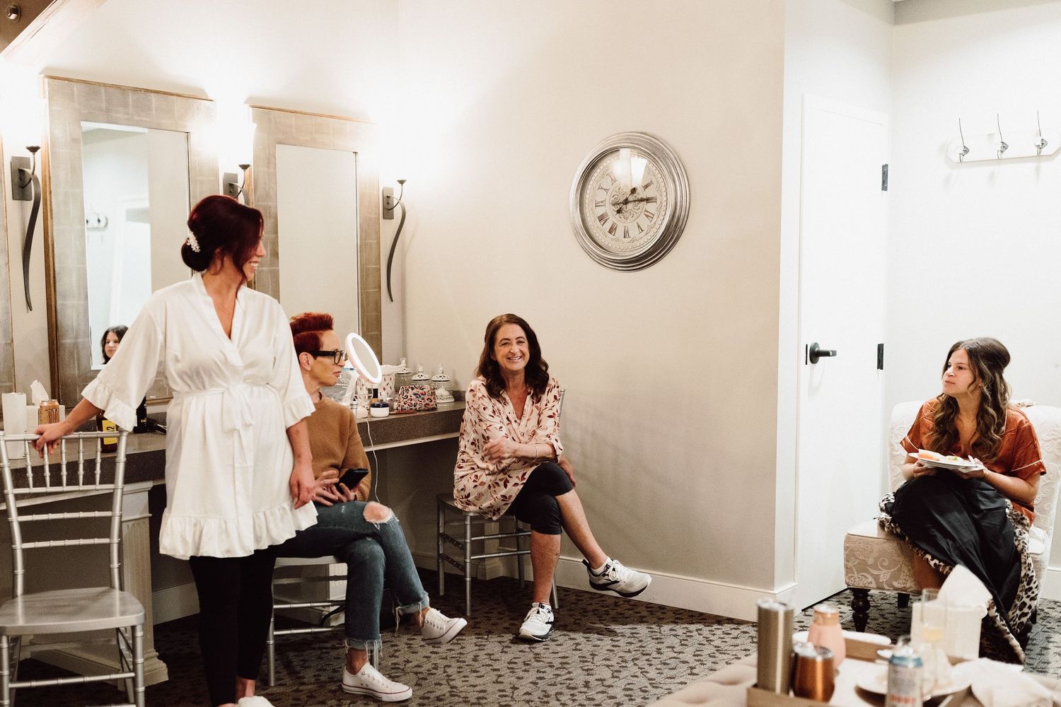 Interior of a bridal preparation room with mirrors and bright lighting.