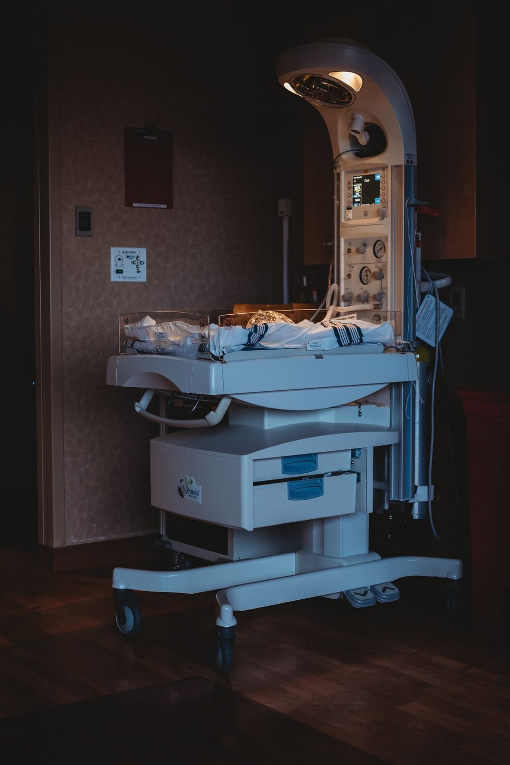 Empty hospital beds with medical equipment in a dimly lit room.  fresh 48, birthing session