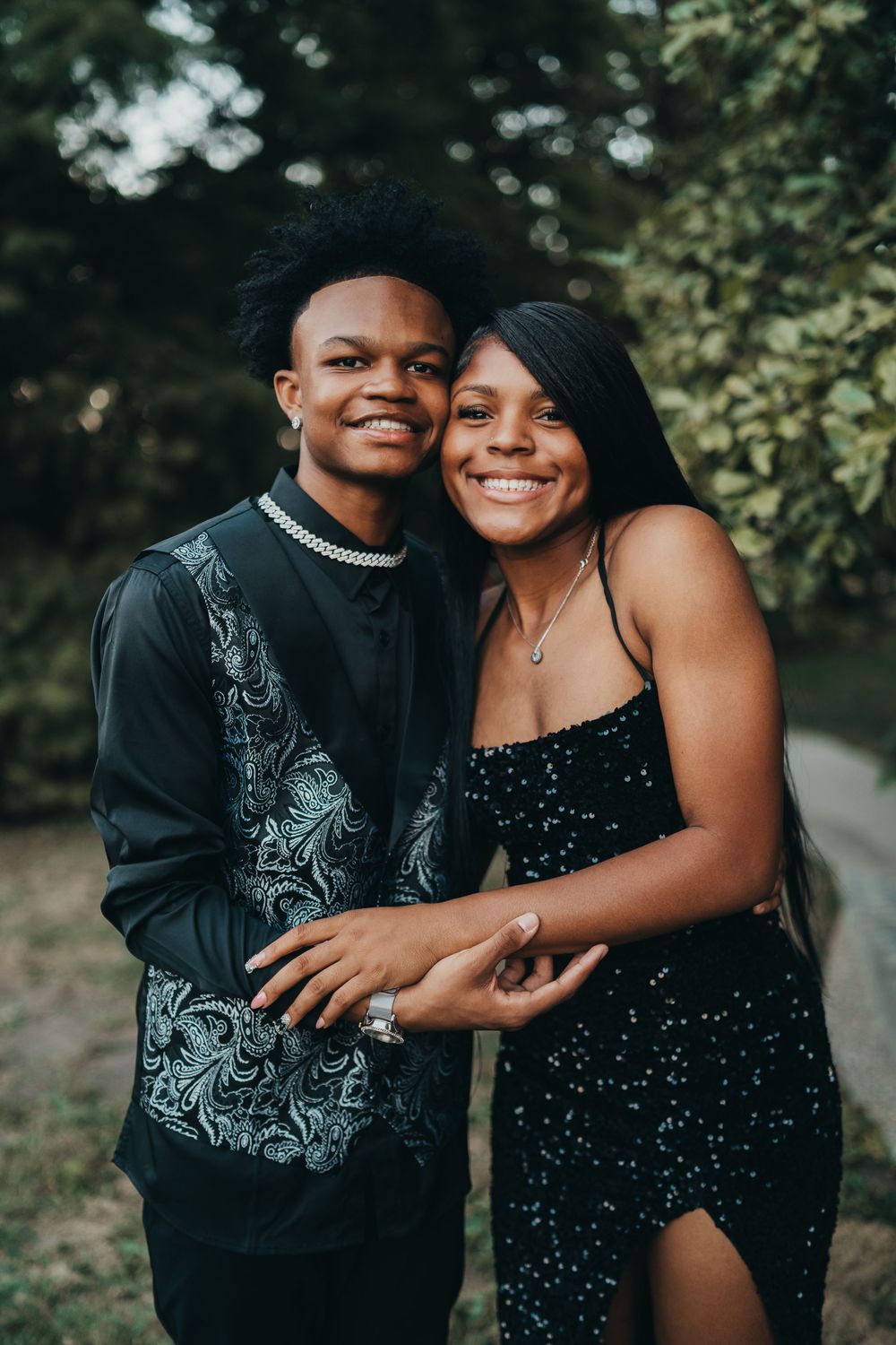 Two people share an affectionate moment during an outdoor photoshoot. Homecoming