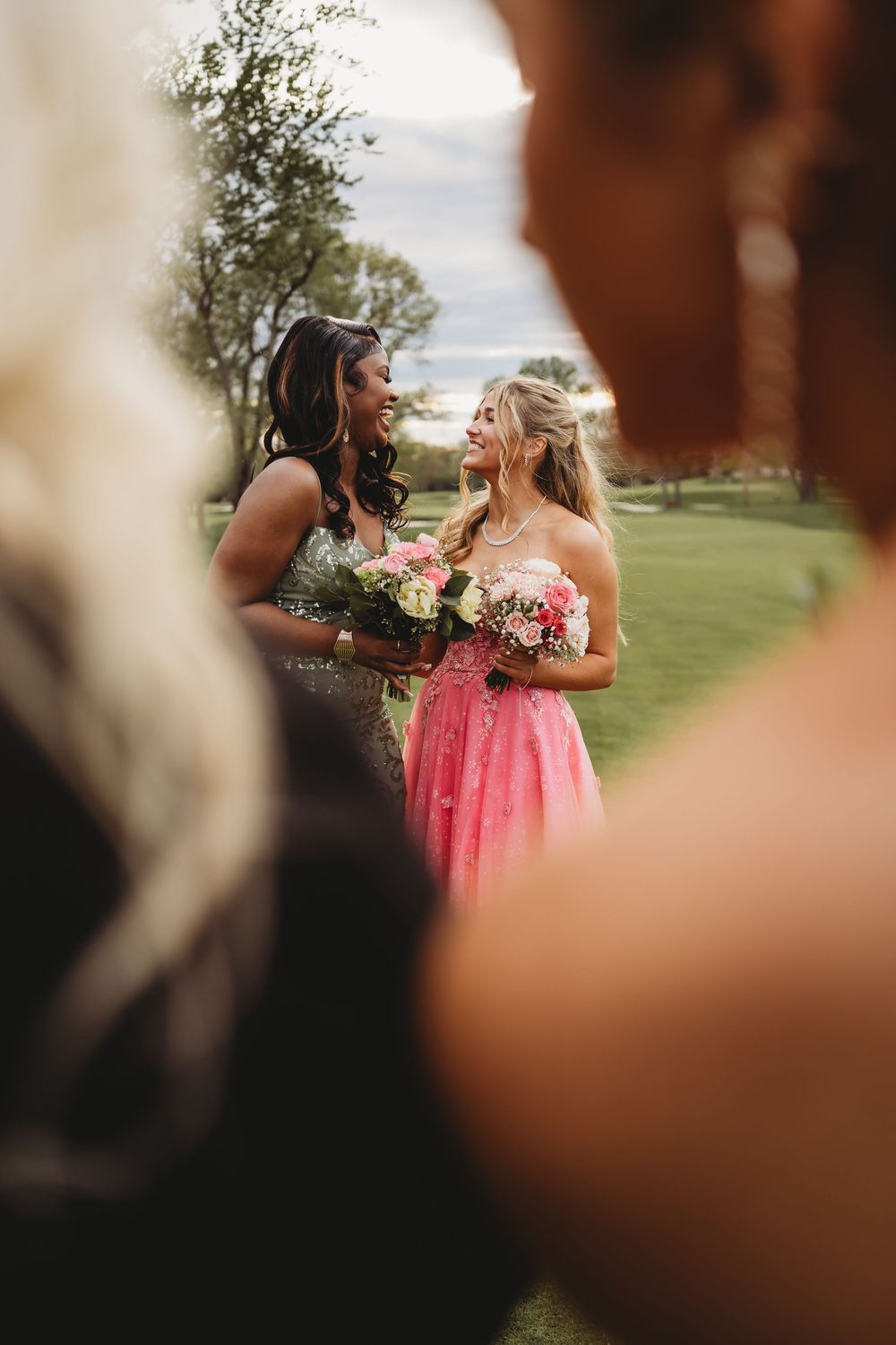 A candid outdoor gathering with people in formal attire sharing joyful moments. prom