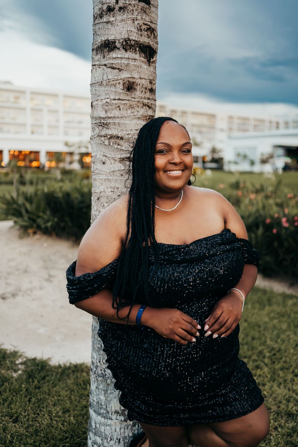 A tropical photoshoot near palm trees on a sunny day with a sparkly black outfit. Portrait images for birthday.
