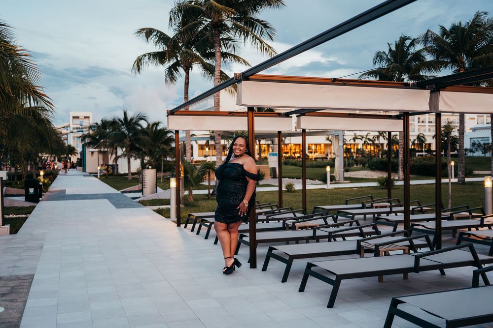 Empty outdoor picnic tables arranged under palm trees at sunset. Portrait