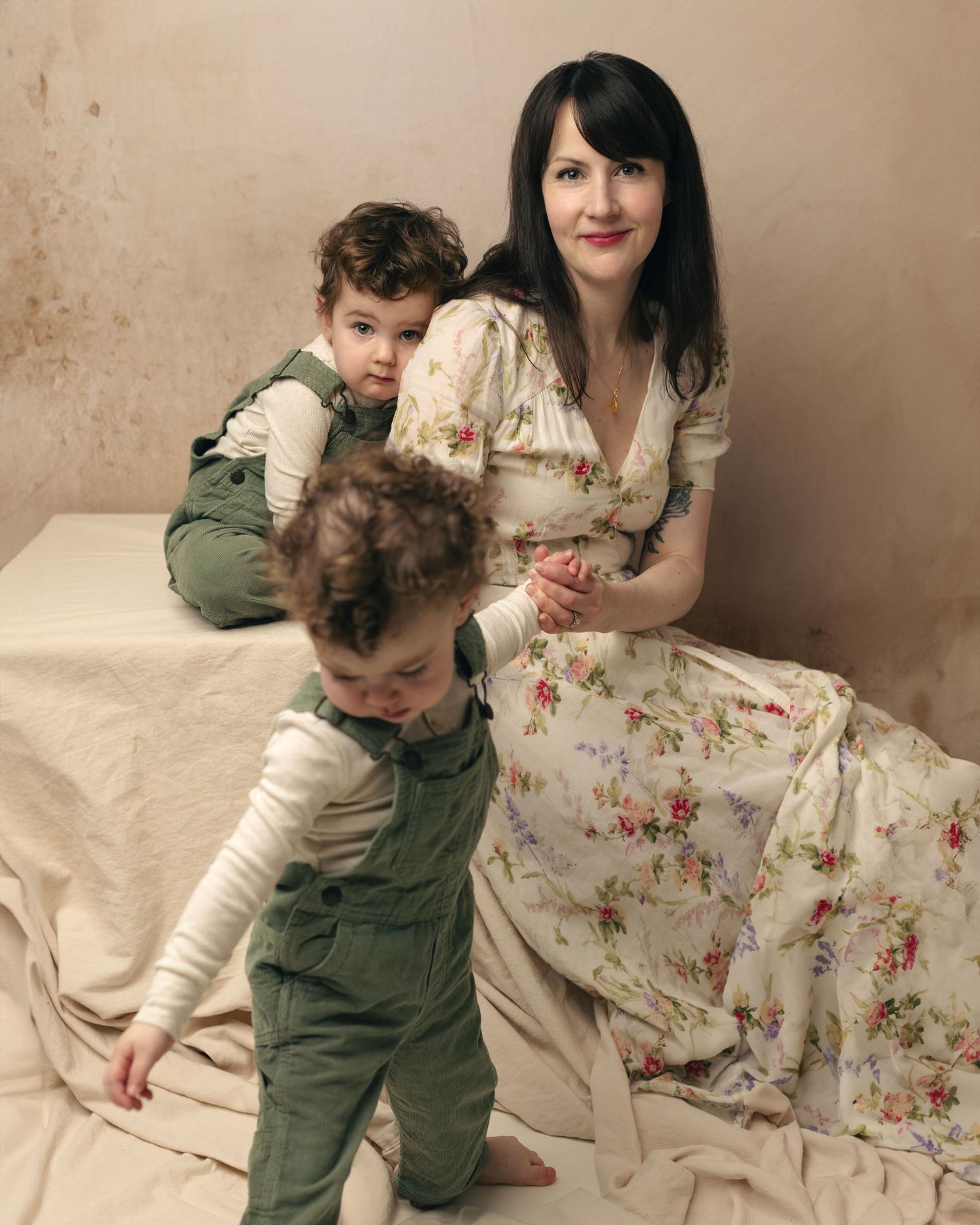 A series of candid moments showing a toddler in green overalls and an adult in a floral dress sitting on a couch together.