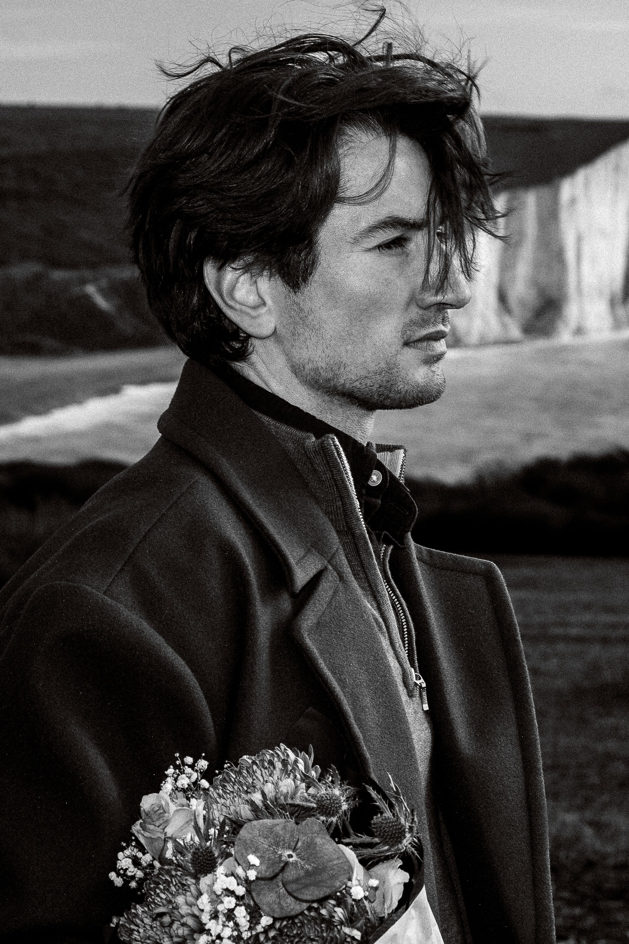 A series of black and white photographs showing a person in a dark coat holding a bouquet of flowers.