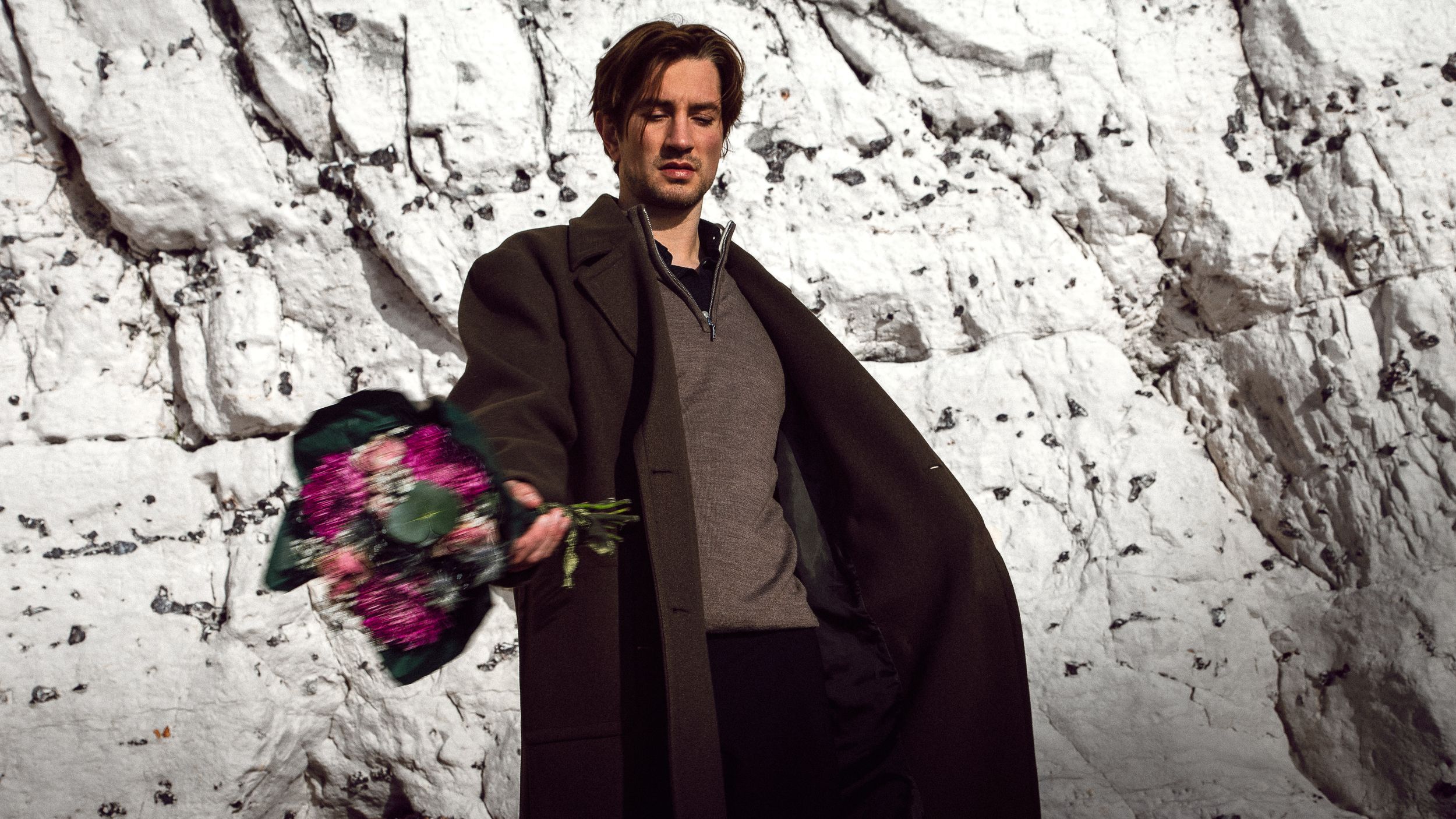 A sequence showing movement against a white stone wall background in dramatic lighting.