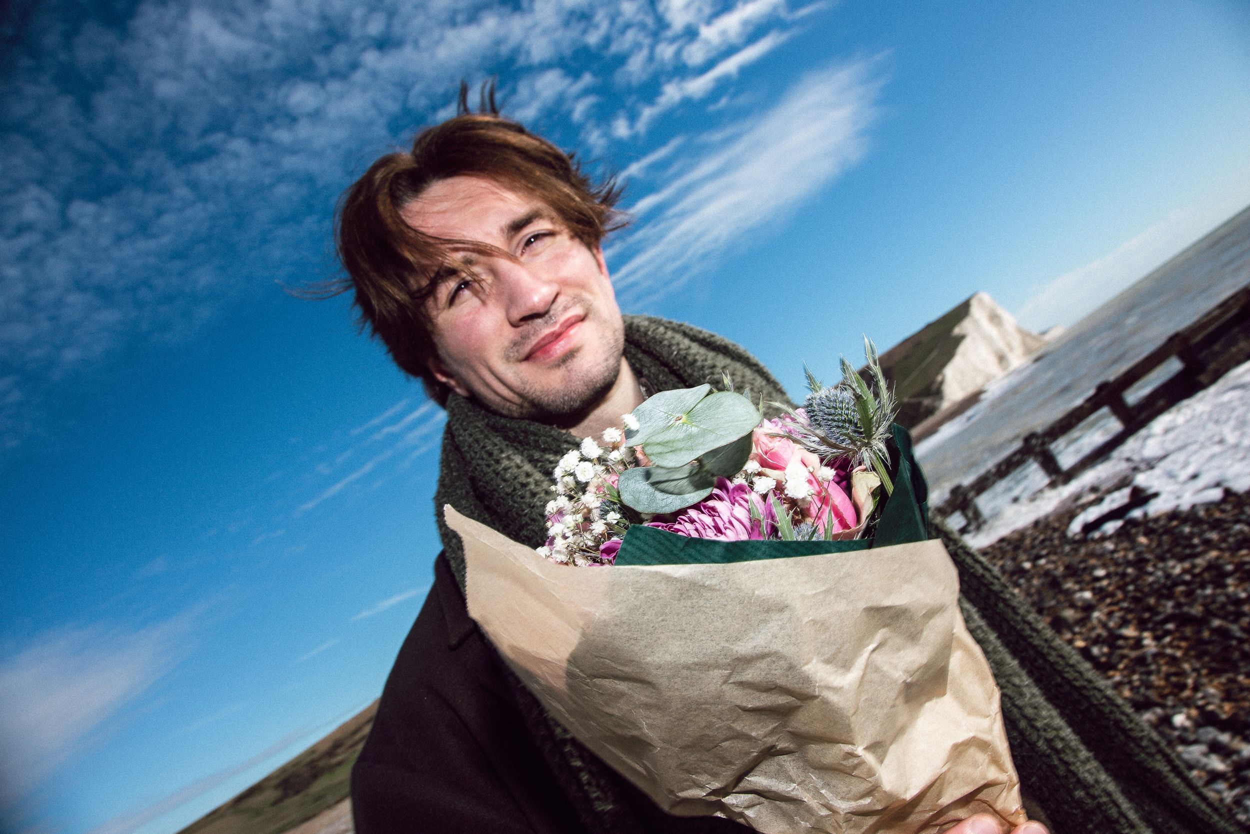 A sequence of candid outdoor portraits taken on a sunny day against a bright blue sky.