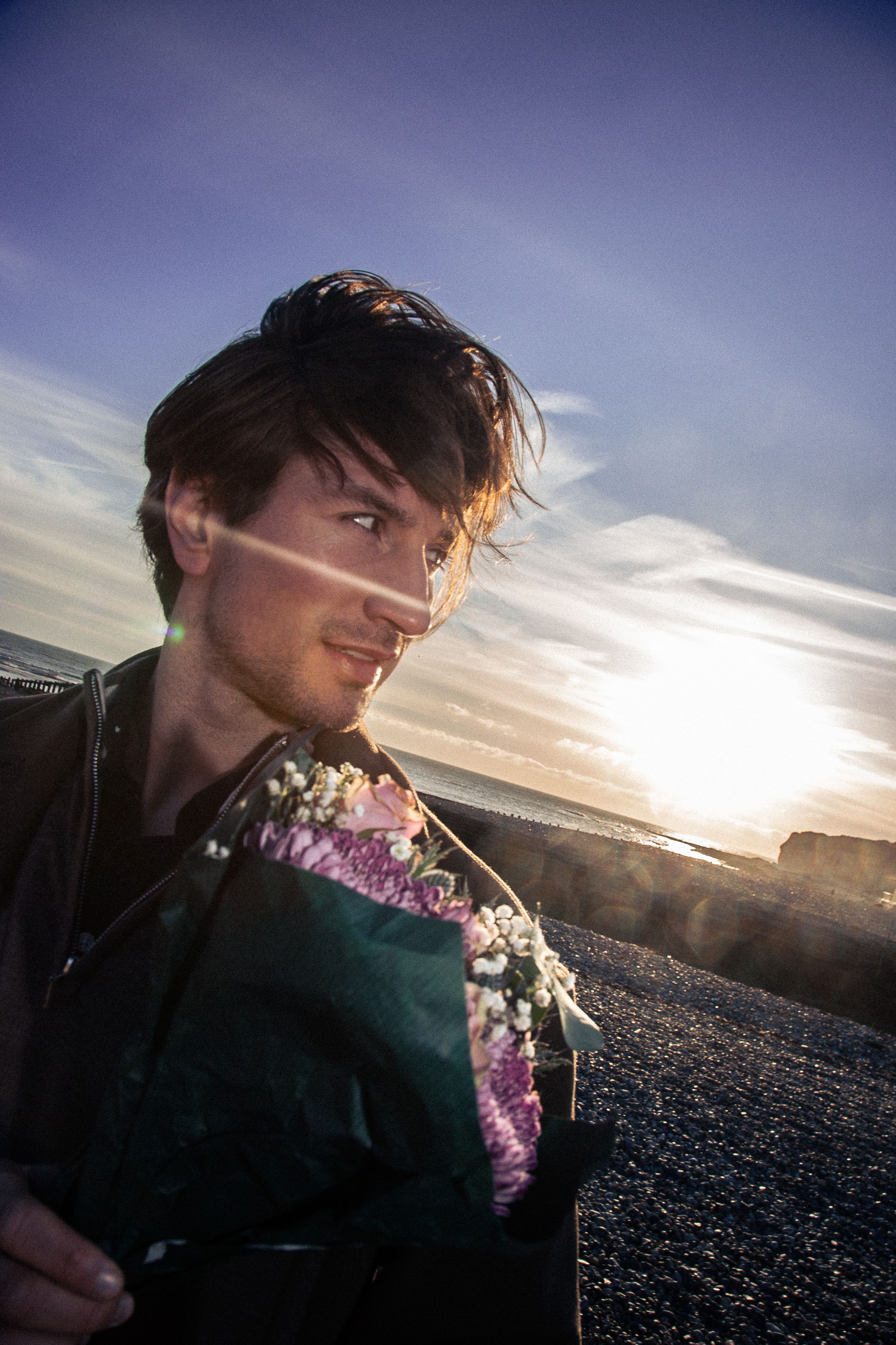 A series of sunset photos showing someone holding purple flowers against a dramatic sky background.