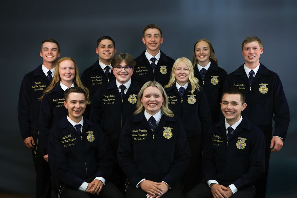 Group photo of FFA members in traditional blue corduroy jackets posing together for formal portraits.