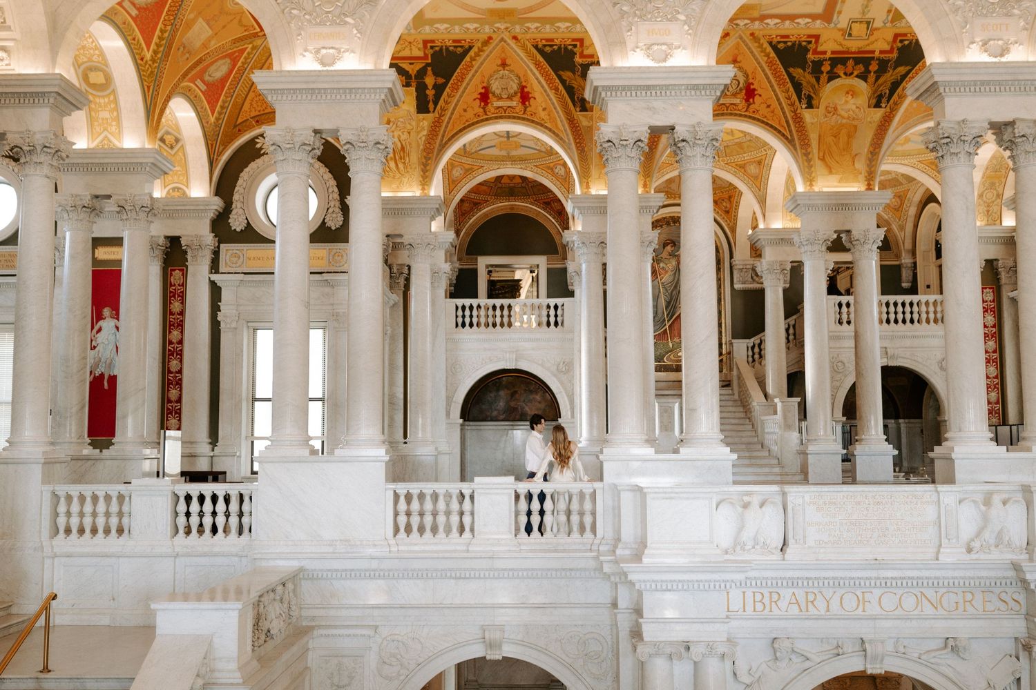 Couple shares a romantic moment on the grand marble staircase of the Library of Congress Great Hall.