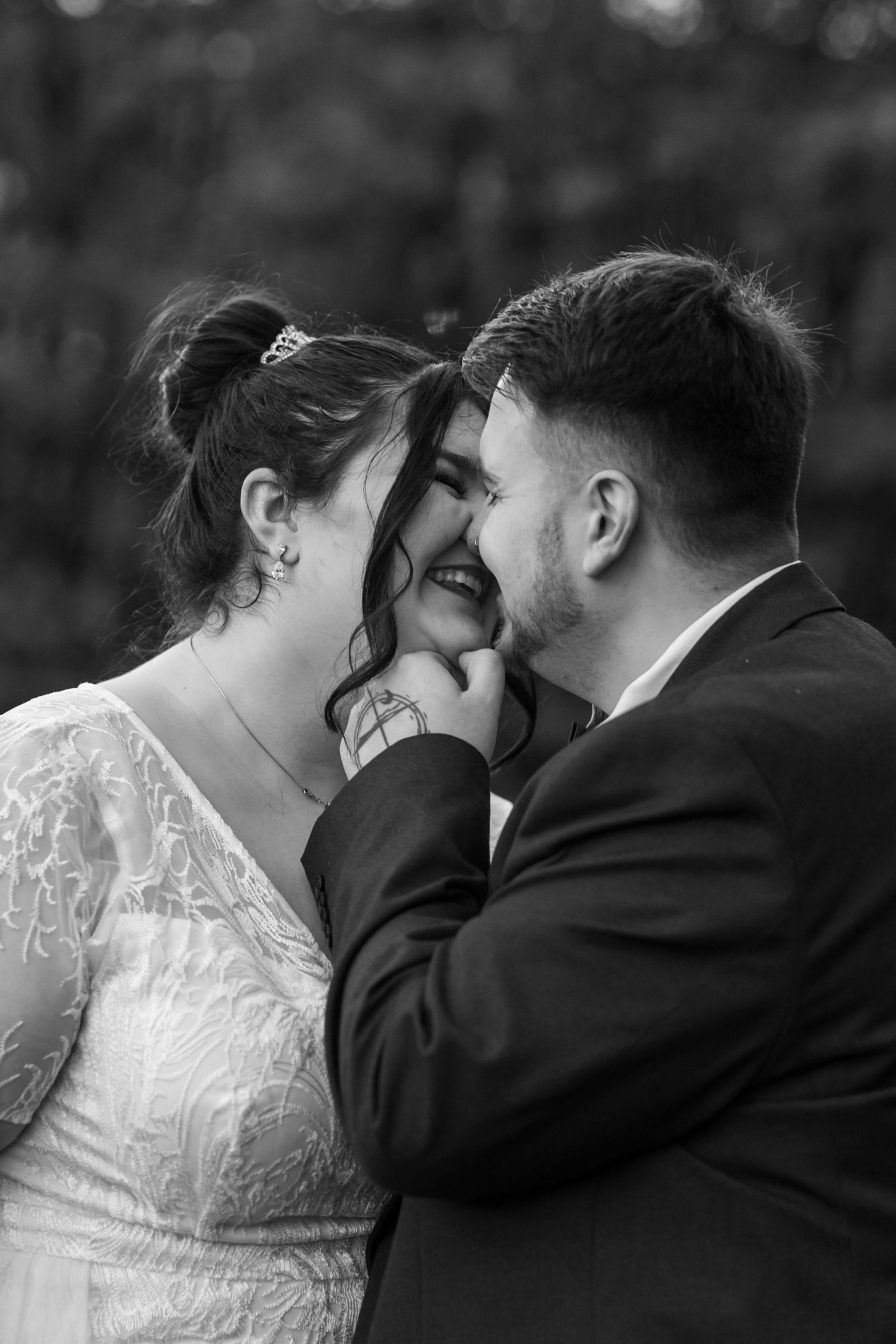 A romantic black and white sequence of a bride and groom sharing tender kisses during their wedding photoshoot.