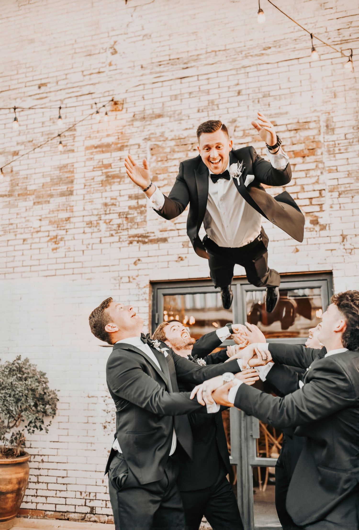 Groom laughing with his groomsmen during candid wedding moment
