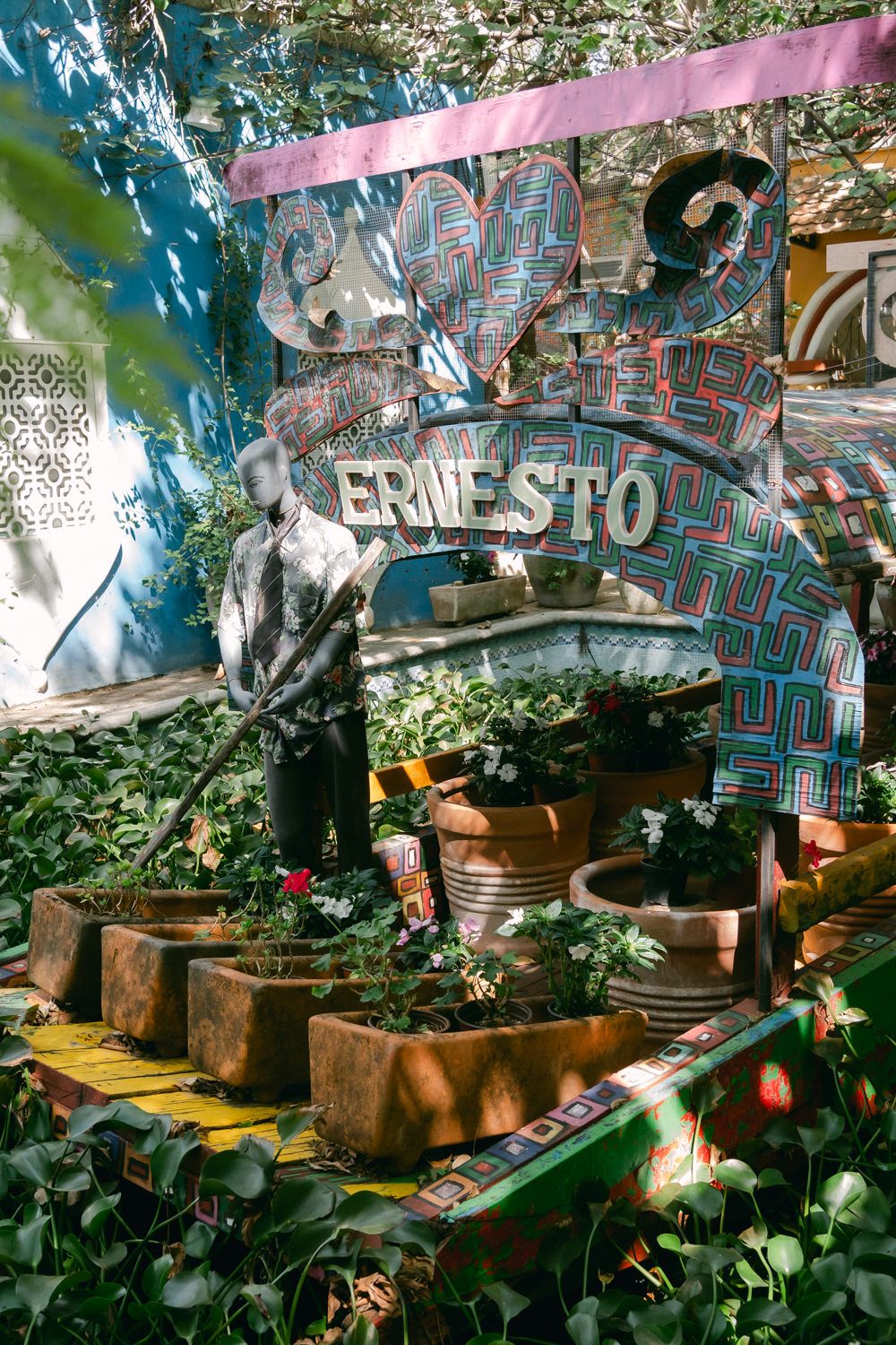 Rustic wooden planters with green plants under a graffiti-covered wall create an urban garden atmosphere.