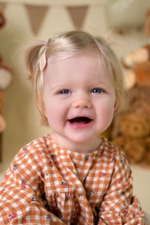 A child wearing an orange and white gingham shirt shows different playful expressions in a series of photos.