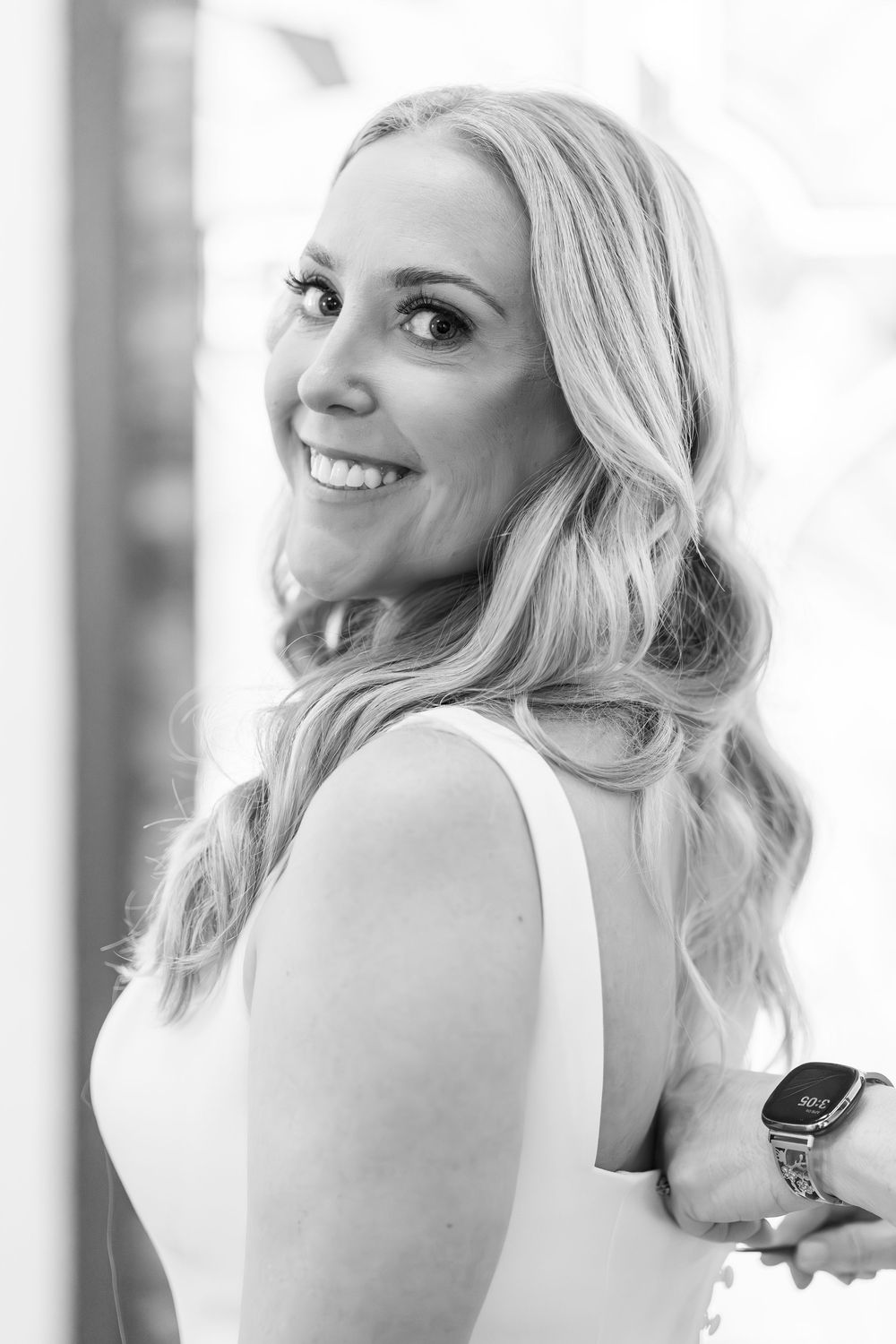 Black and white portrait series showing a person with blonde wavy hair smiling and looking over their shoulder.